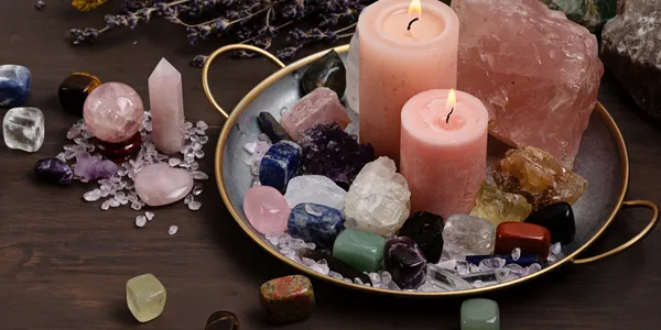 A tray with lit pink candles, crystals, and stones for relaxation.