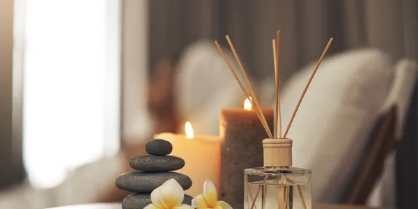 Serene spa setting with candles, stacked stones, and flowers.